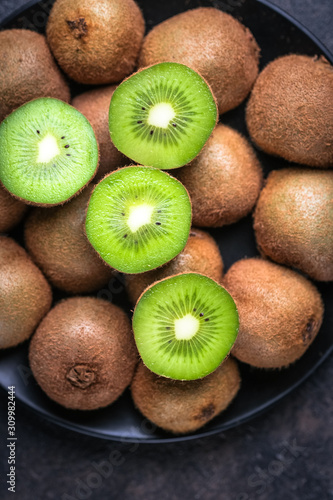 Ripe fresh kiwi fruits  on dark background. Top view with  copy space.