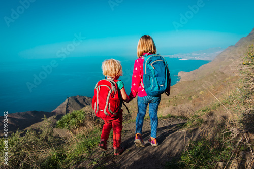little girls hiking in mountains near sea