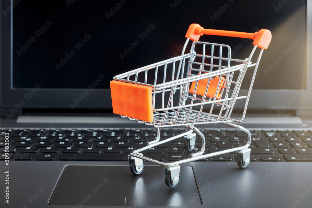 Online shopping concept with a shopping cart on a laptop computer