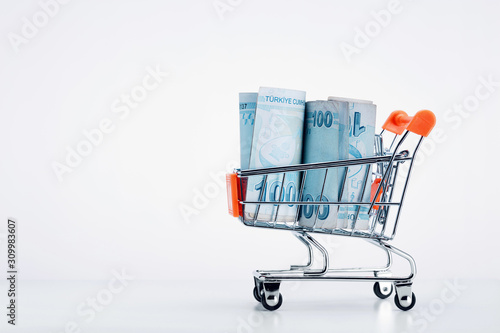 Shopping cart trolley full of Turkish lira bills on white background