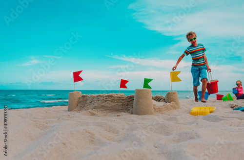 Wallpaper Mural sand castle and kids building it on beach vacation Torontodigital.ca