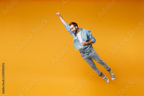 Fototapeta Funny young bearded man in casual blue shirt posing isolated on yellow orange background, studio portrait