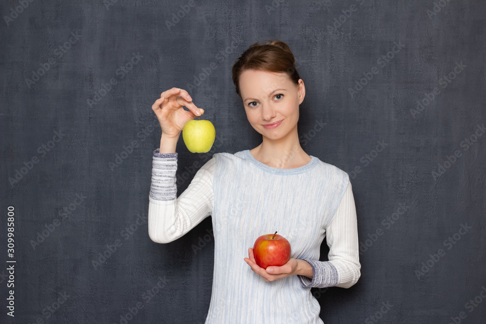 Portrait of happy young woman smiling and holding two ripe apples Portrait of happy young woman smiling and holding two ripe apples