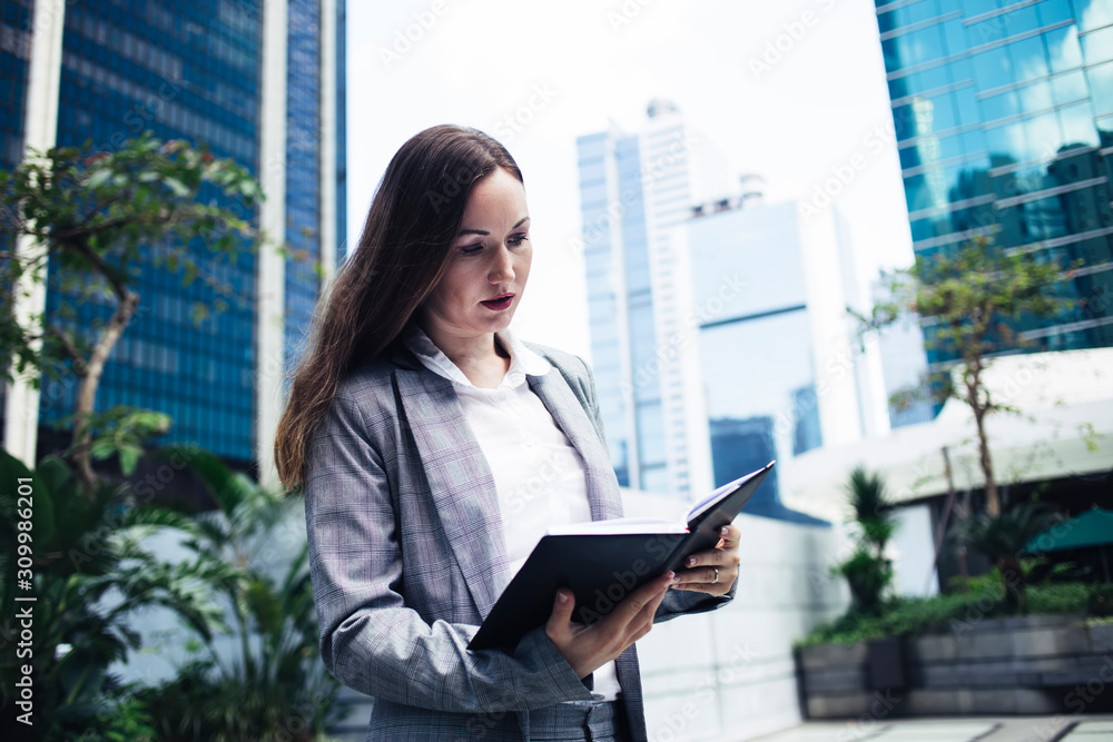 Business woman with notebook walking in city