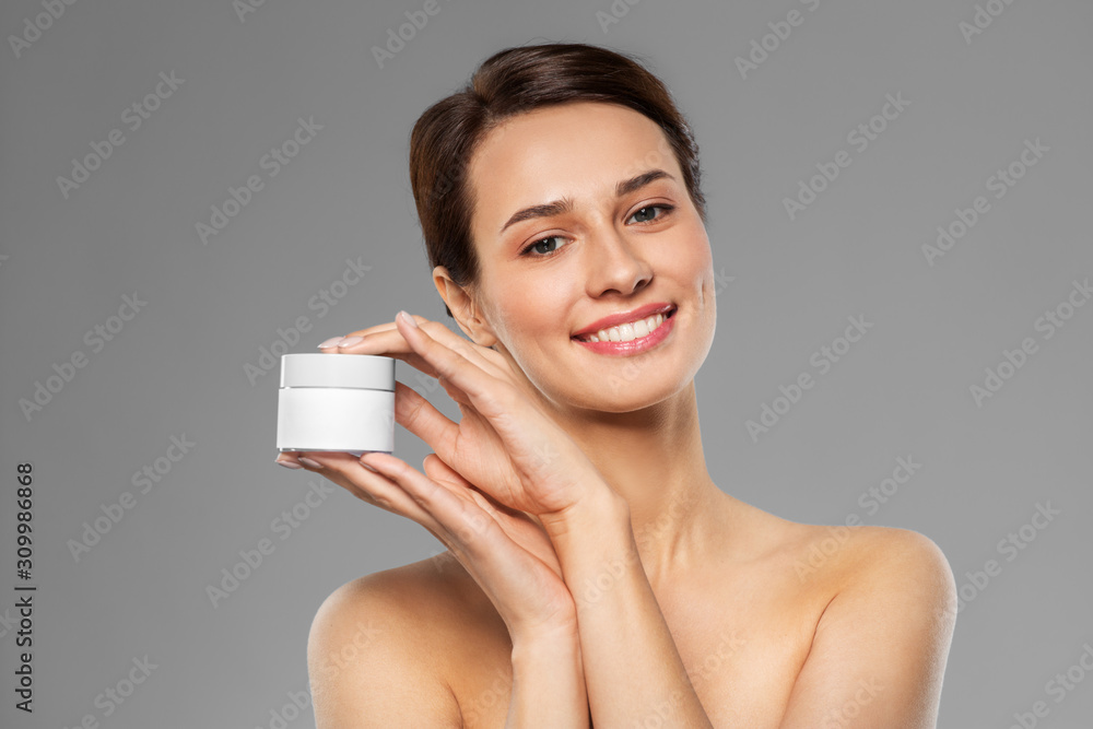 beauty, cosmetics and skincare concept - happy young woman holding jar of cream over grey background beauty, cosmetics and skincare concept - happy young woman holding jar of cream over grey background