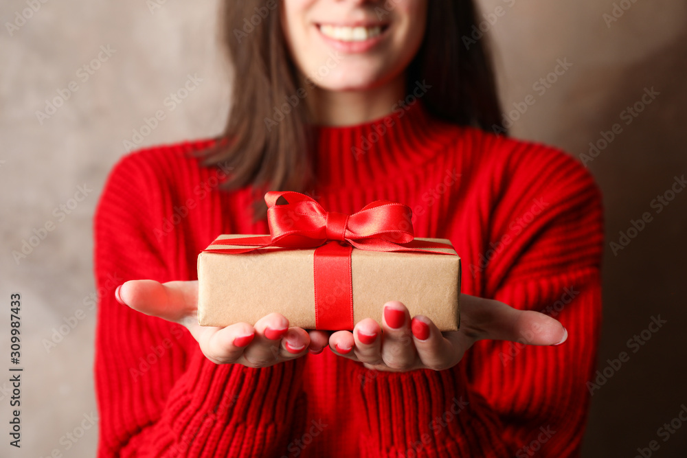 Woman with smile holding gift boxes on brown background, closeup. Space for text Woman with smile holding gift boxes on brown background, closeup. Space for text