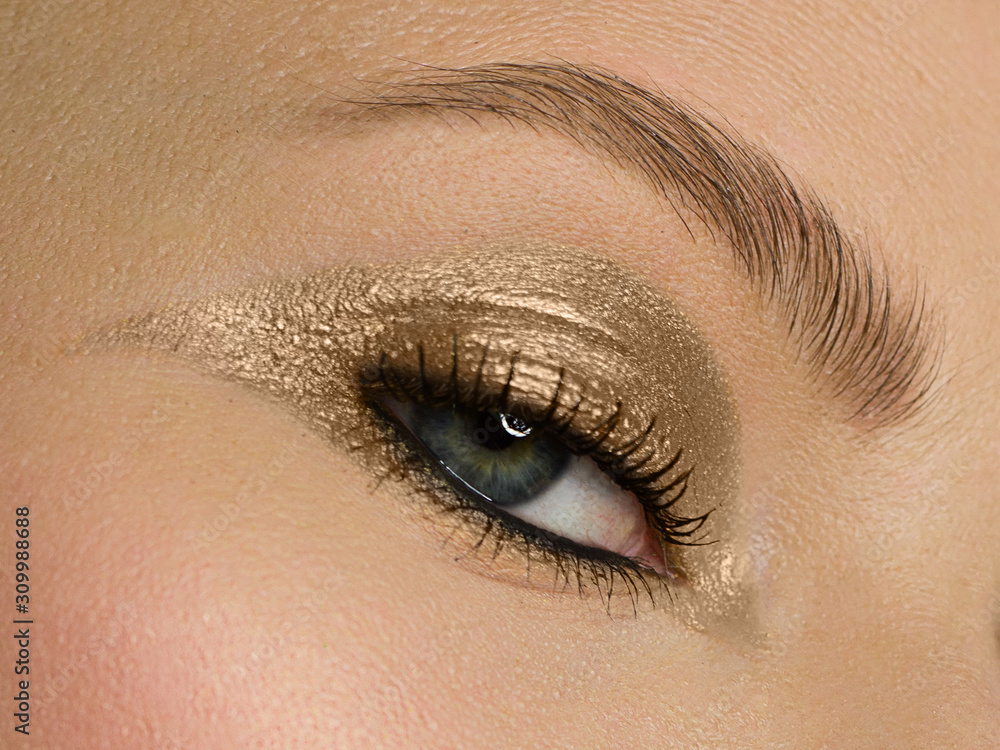 Obraz premium Beauty close-up portrait of model face of beautiful young woman with clean skin. Wellness, skin care and bright black liner and silver make-up. extremely long eyelashes and a bushy eyebrow