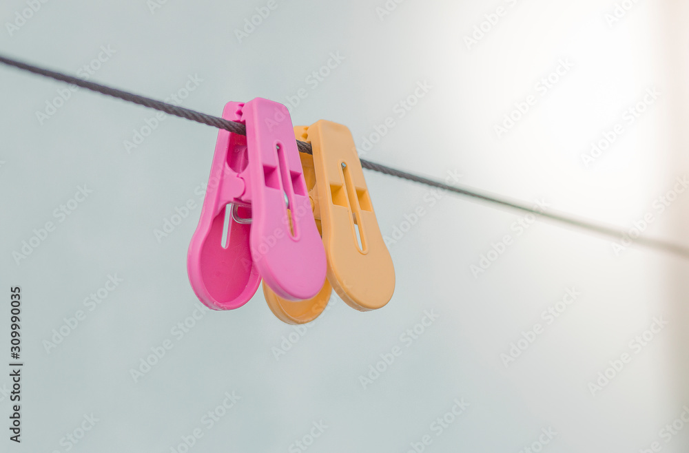 plastic clothespins pink and yellow color on wall background, Colorful plastic clothespins on the hangers. plastic clothespins pink and yellow color on wall background, Colorful plastic clothespins on the hangers.