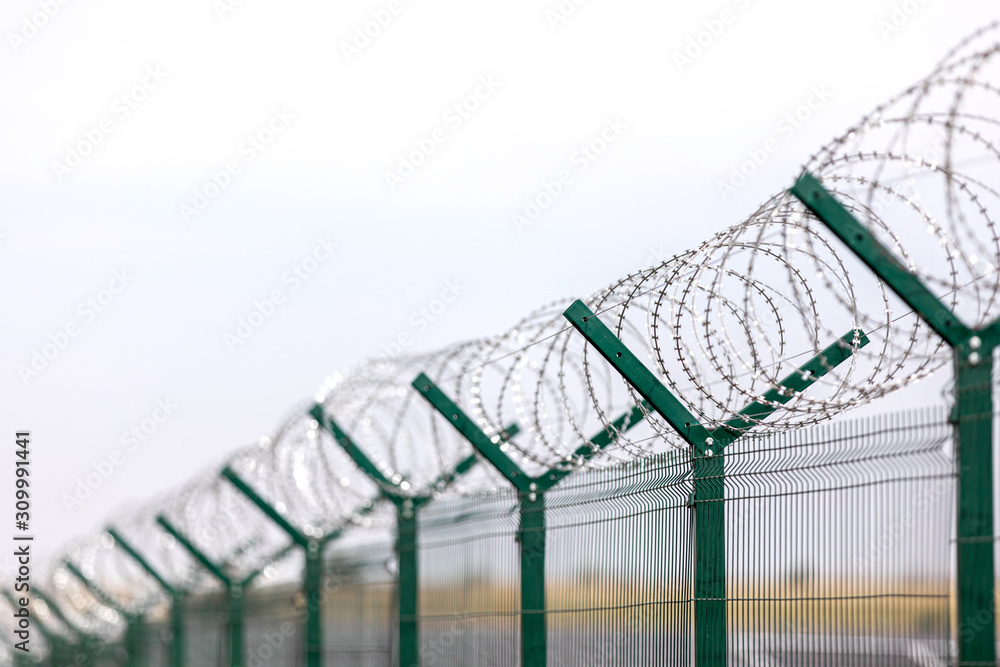 Security with a barbed wire fence. Fencing of sensitive sites with barbed wire. Security with a barbed wire fence. Fencing of sensitive sites with barbed wire.