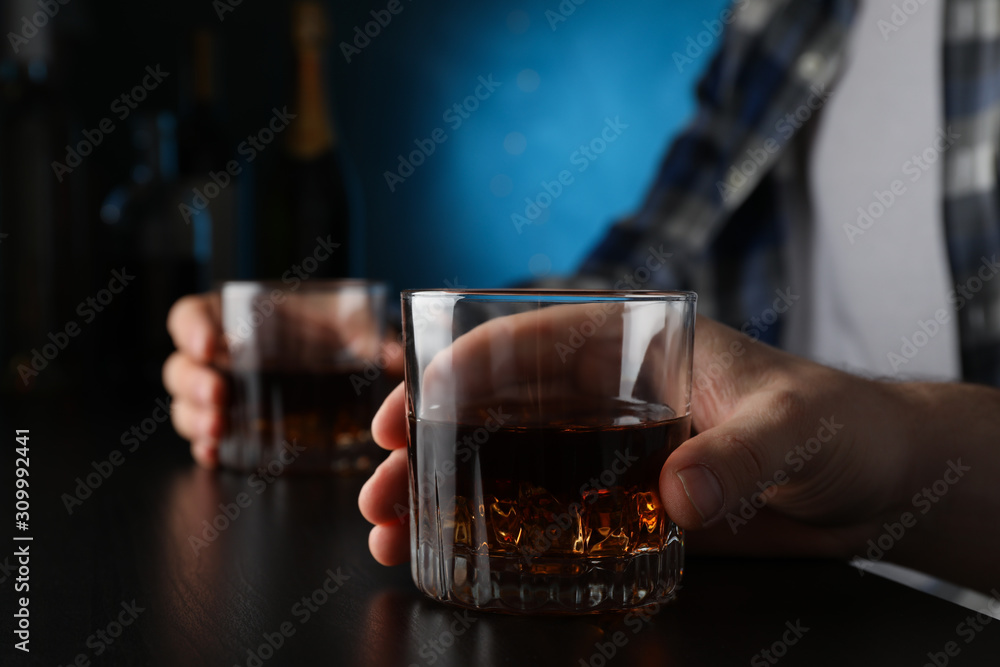 Men holding glasses of whiskey at the bar, space for text