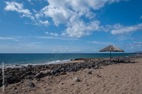 Empty beach with one umbrellaand open sea view