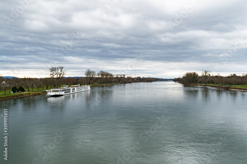 the Rhine river and an anchored river cruise ship near Strasbourg © makasana photo