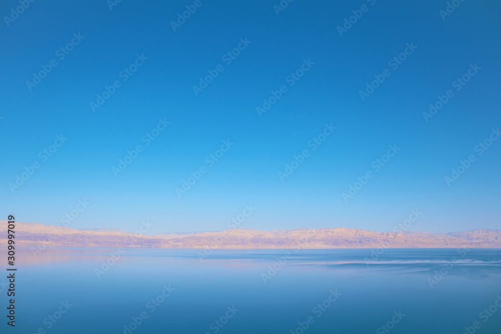 Beautiful view of salty Dead Sea with clear blue sky and water. Ein Bokek, Israel.