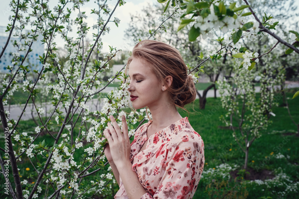 Young beautiful woman in the cherry-blossoming garden. Young beautiful woman in the cherry-blossoming garden.