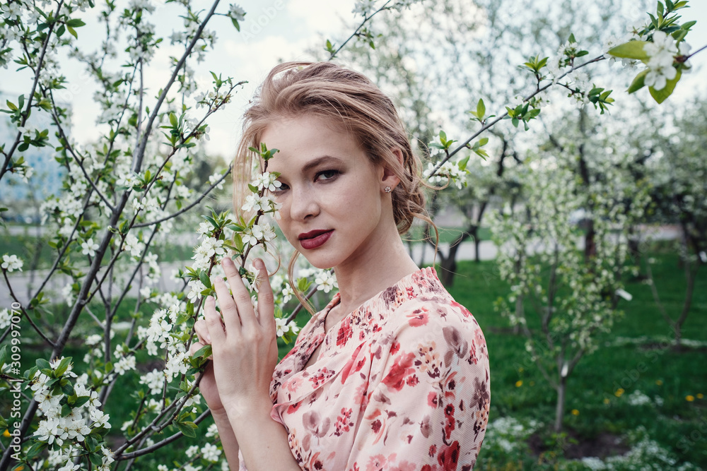Young beautiful woman in the cherry-blossoming garden. Young beautiful woman in the cherry-blossoming garden.
