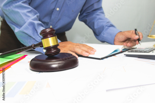 Business lawyer writing hard at office desk workplace with paper and documents.concept