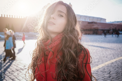Happy women walking in red coat at the red square in Moscow