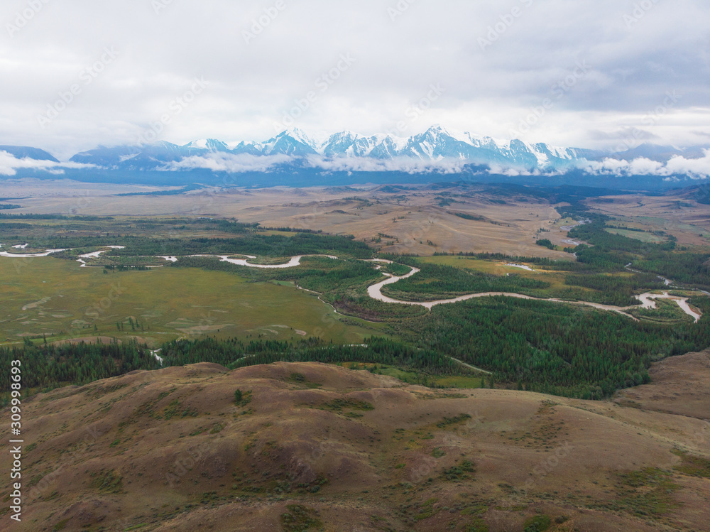 Aerial view of Kurai steppe and Chuya river on North-Chui ridge background. Altai mountains, Russia.