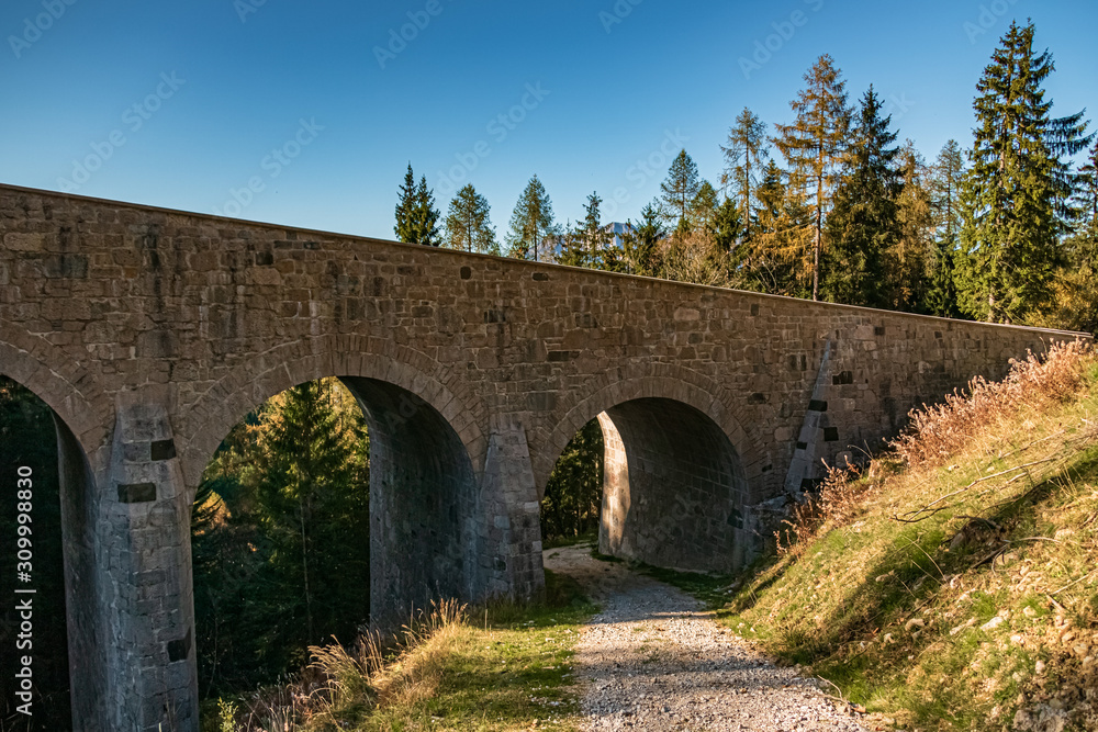 Beautiful alpine autumn or indian summer view with an old stone bridge at the famous Rossfeldstrasse, Berchtesgaden, Bavaria, Germany