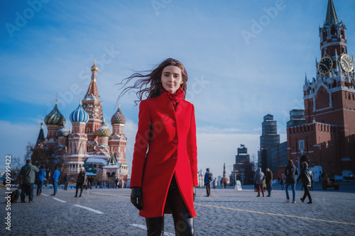 Happy women walking in red coat at the red square in Moscow