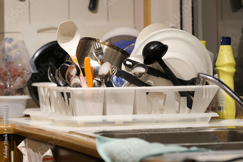 Plates, cups, forks and ladles placed on a kitchen tray.