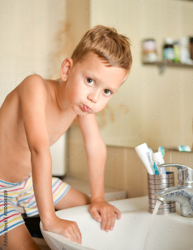 boy rinses his mouth in bathroom over sink boy rinses his mouth in bathroom over sink