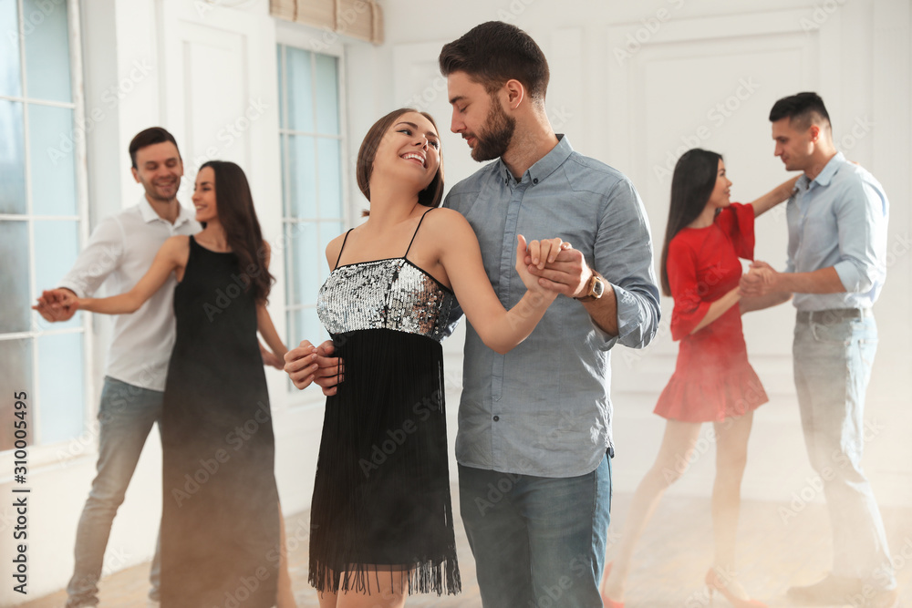 Lovely young couple dancing together at party - obrazy, fototapety, plakaty 