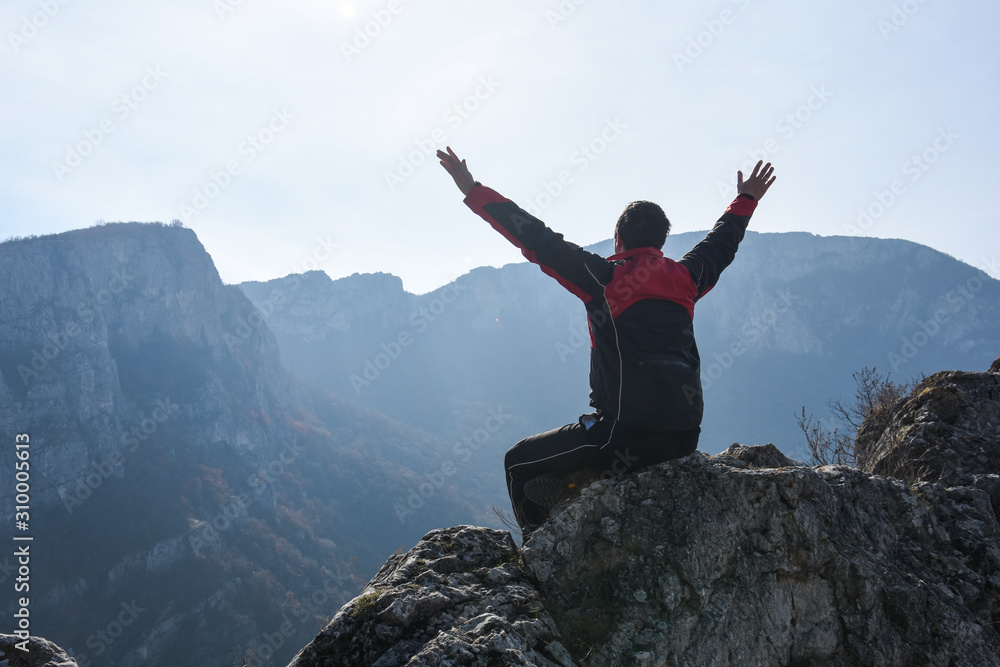 Adventurous man is standing on top of the mountain and enjoying the beautiful view. A man stands on the edge of a cliff in Sicevo Gorge, Serbia. Travel Lifestyle emotional concept Adventurous man is standing on top of the mountain and enjoying the beautiful view. A man stands on the edge of a cliff in Sicevo Gorge, Serbia. Travel Lifestyle emotional concept