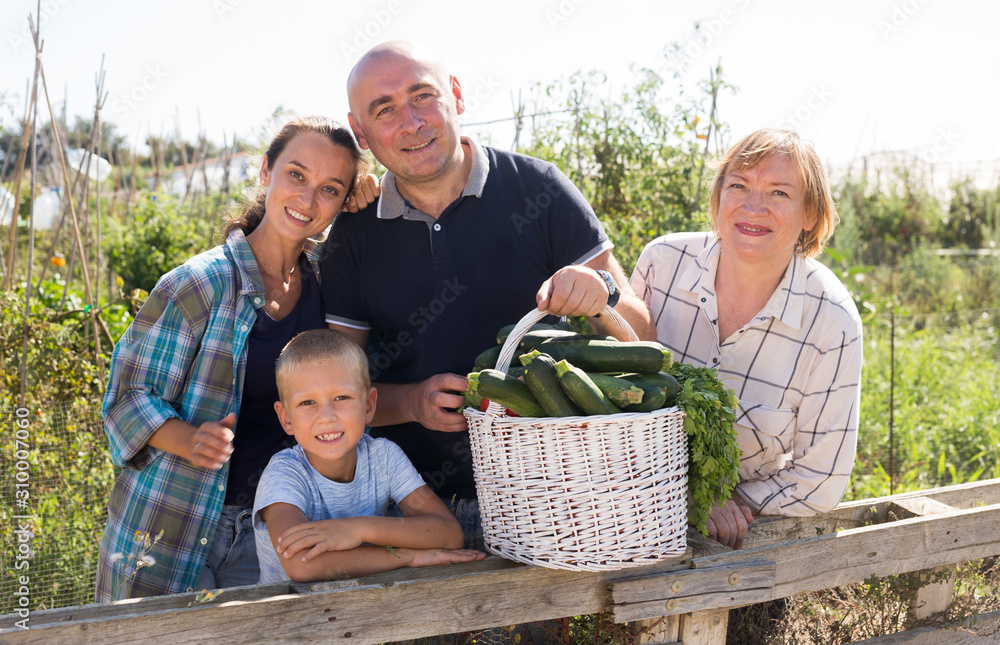 Family in garden with gathered vegetables