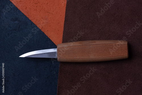 craft knife lies, on pieces of leather, different colors