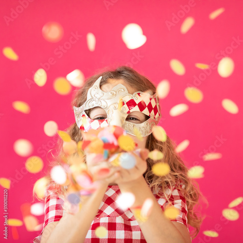 Fancy girl blowing confetti against pink bakground