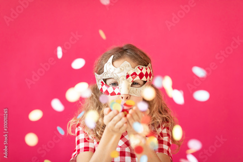 Photographie Fancy girl blowing confetti against pink bakground