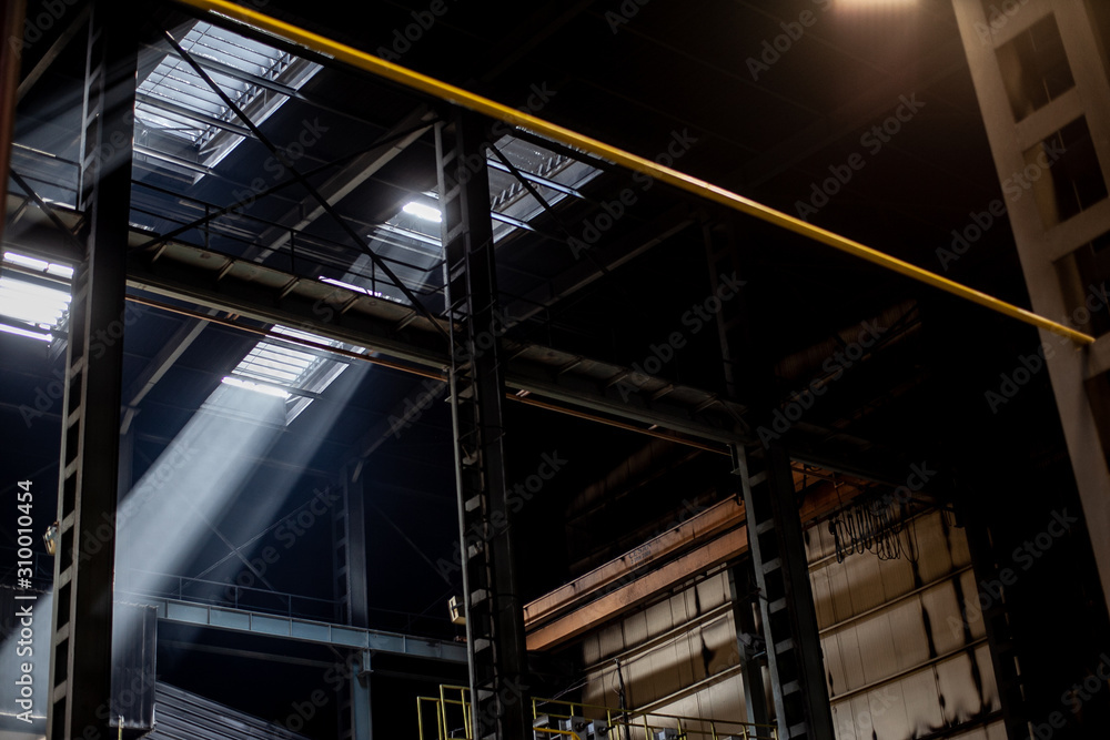 Interior of modern industrial production plant in beams of luminous lights