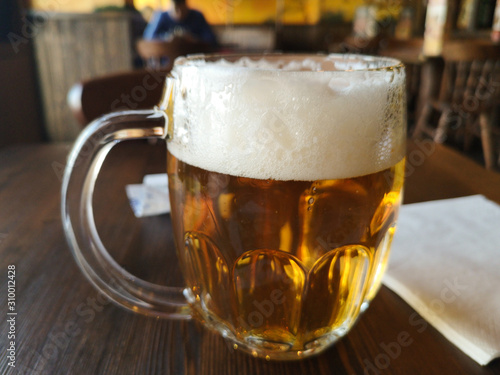 bicchiere di birra con schiuma con sottofondo  photo