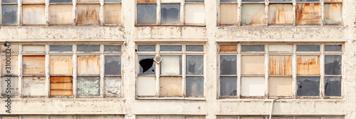 A row of boarded up windows of a building marked for demolition