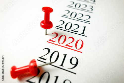 Year 2020 with red pushpin on paper sheet