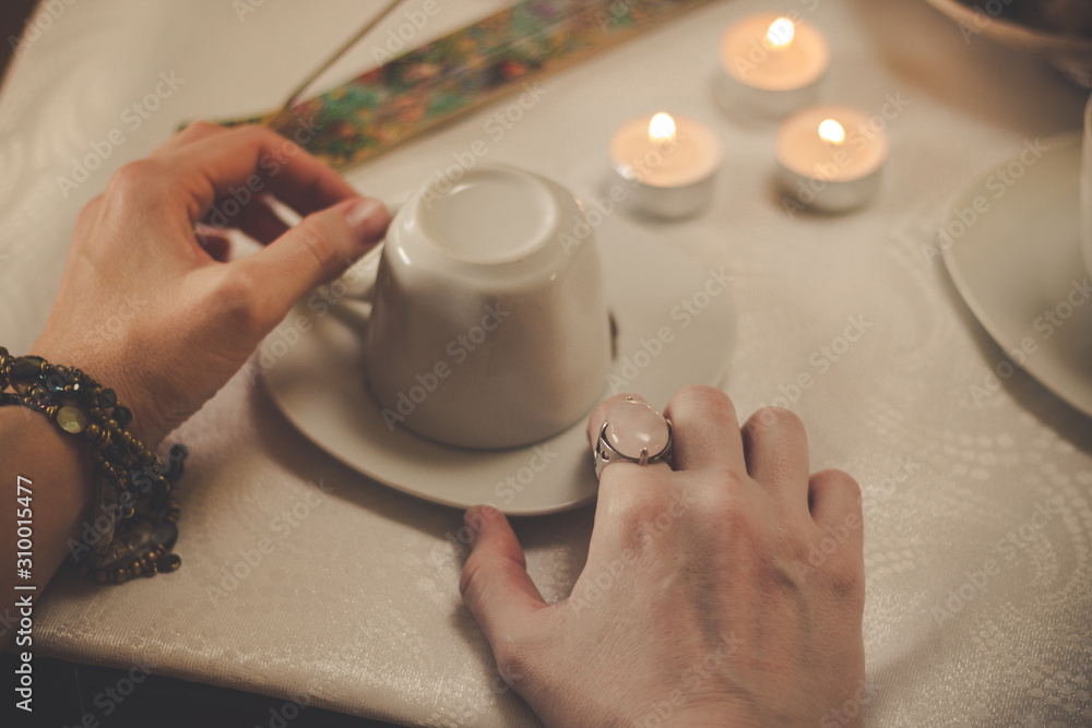 Coffee ground fortune teller, holding cup of coffee, close up Coffee ground fortune teller, holding cup of coffee, close up