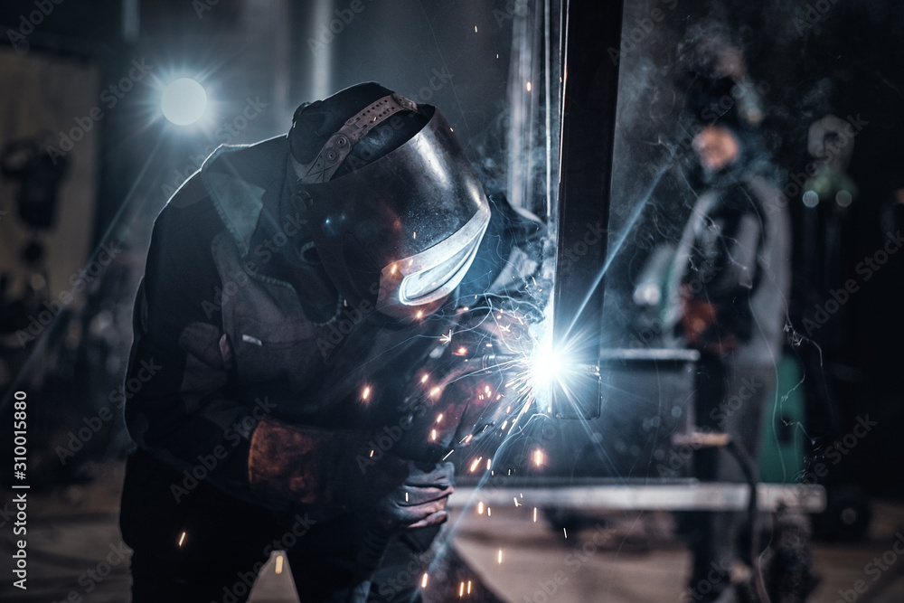 © Fxquadro - Man is working at metal factory, he is welding a piece of rail using special tools. © Fxquadro - Man is working at metal factory, he is welding a piece of rail using special tools.