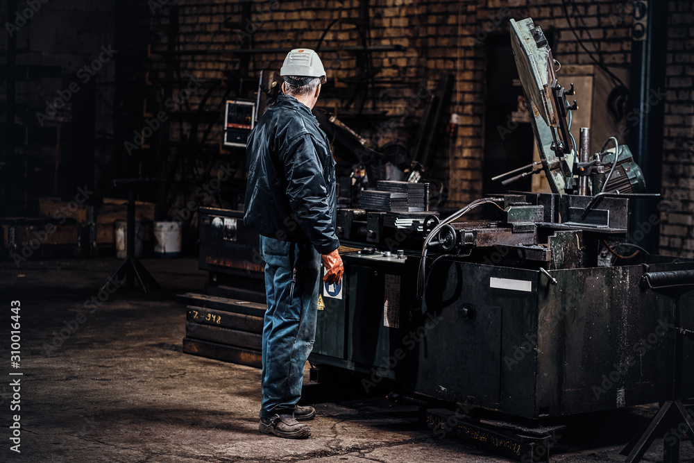 Experienced worker is working at metal factory using special machine tool. Experienced worker is working at metal factory using special machine tool.