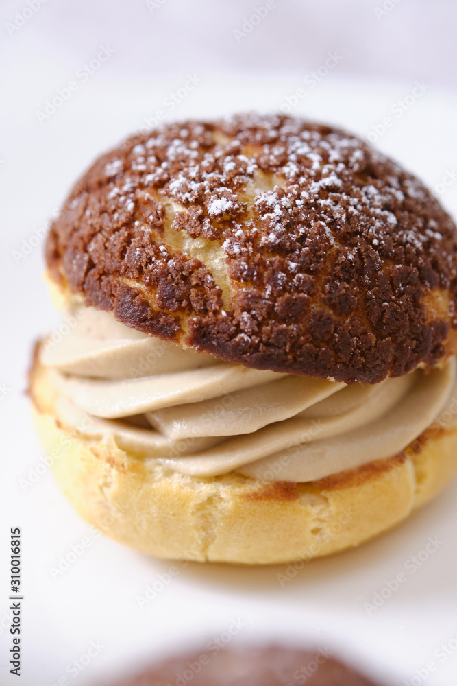 choux cream or cream puff or French profiteroles with fresh cream set on cafe table. choux cream or cream puff or French profiteroles with fresh cream set on cafe table.