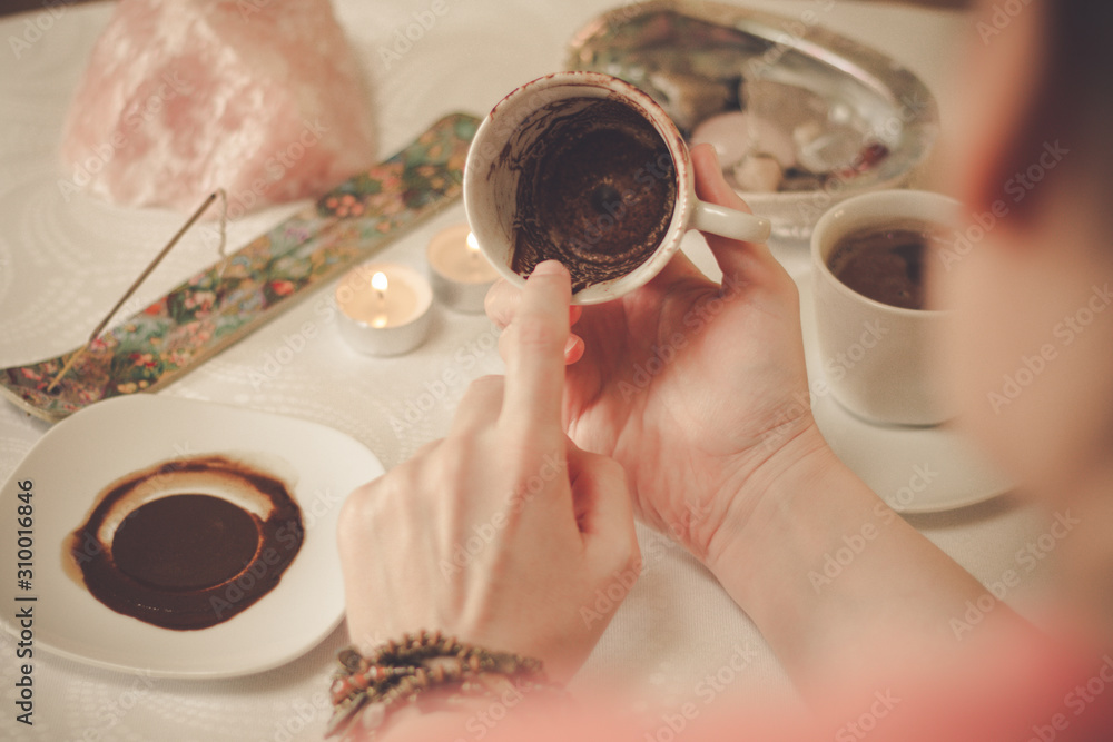 Coffee ground fortune teller, holding cup of coffee, close up