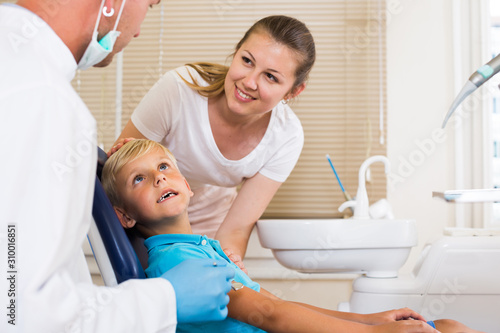 Son with mother are visiting dentist
