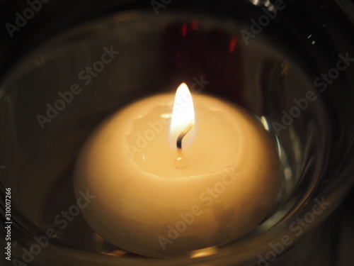 Round floating white candle with flame