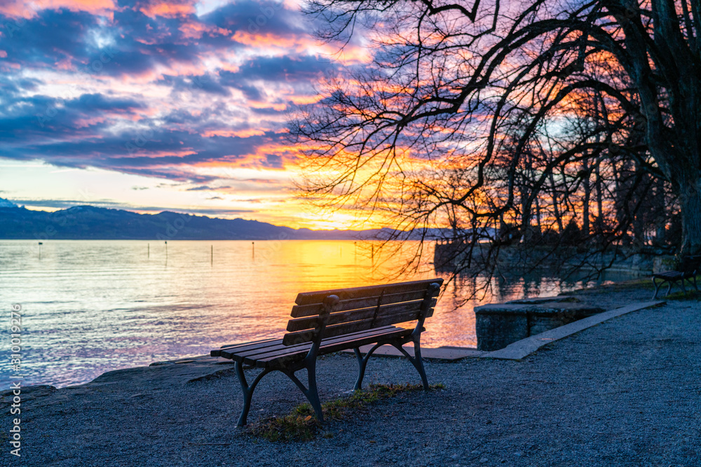 Sitzbank direkt am Ufer atmosphärische, strahlende, Sonnenuntergang, leuchtende  Wolken, glitzernde Wasserfläche, Lindau, Bodensee, Lindenhofpark