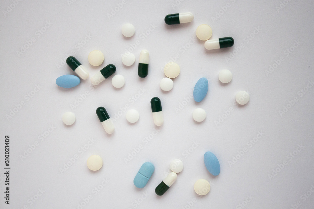 White and blue pills on white background close up White and blue pills on white background close up