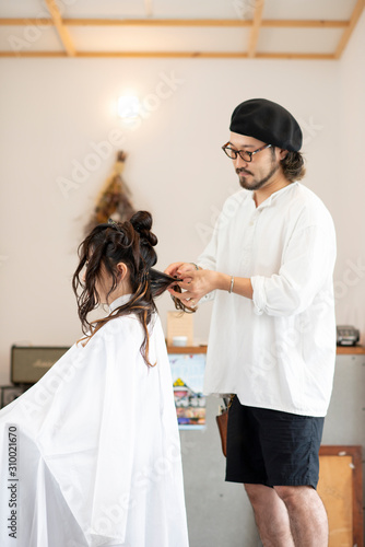 女性のヘアセットをする美容師 photo