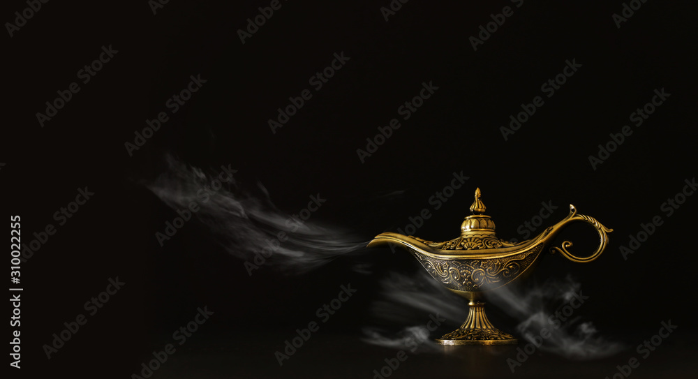 Fototapeta premium Image of magical mysterious aladdin lamp with glitter sparkle smoke over black background. Lamp of wishes