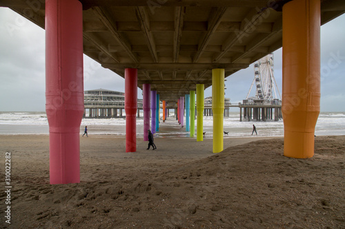 Quadro em tela A glimpse underneath the brightly colored pillars of the Scheveningen pier with a piece of the Ferris wheel in the background