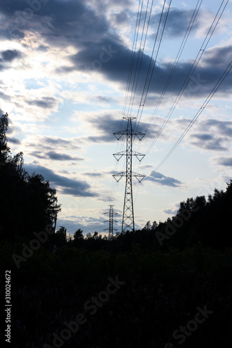 Power line in evening landscape with dramatic clouds