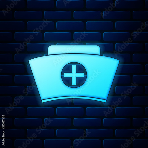 Glowing neon Nurse hat with cross icon isolated on brick wall background. Medical nurse cap sign. Vector Illustration